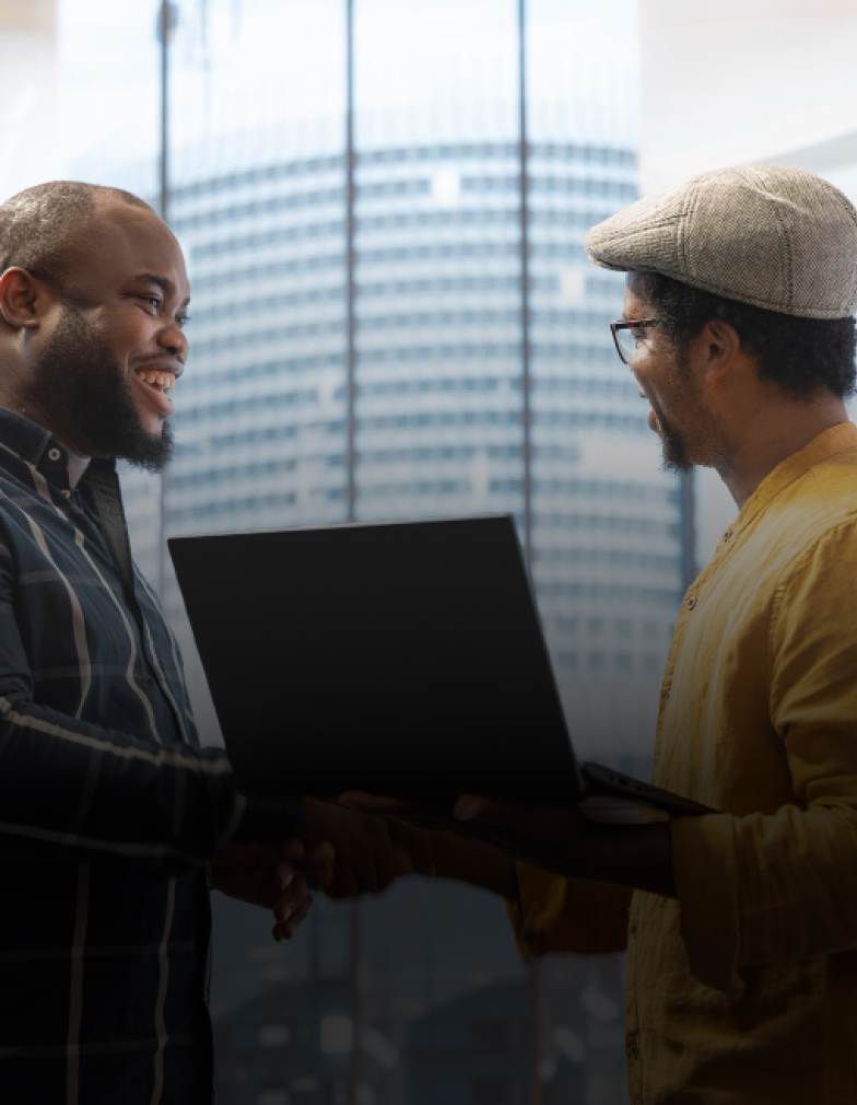 Two people shaking hands outside an office building