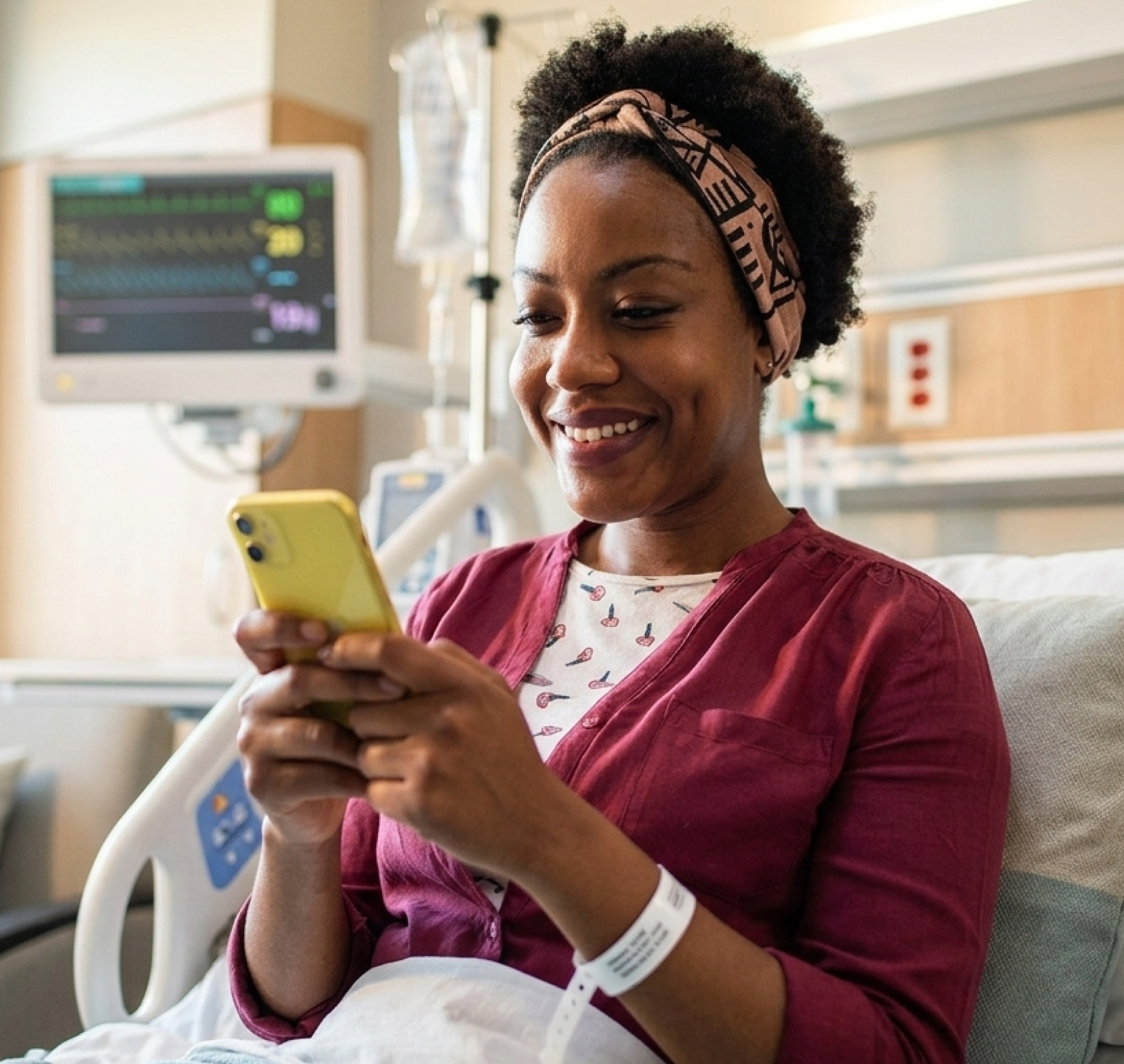 A woman in a hospital bed reviewing her health records on her phone